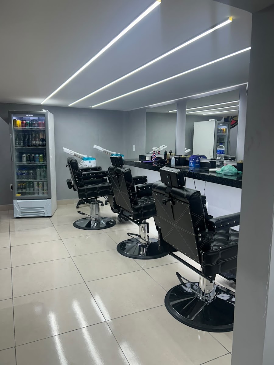 Interior da Sines Barber Club com cadeiras de barbeiro e bancada em granito preto